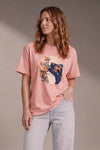 Woman wearing a custom peach relaxed tee with a colorful print