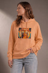 Woman wearing a custom peach hoodie with a portrait print