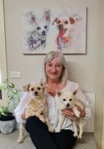 Sarah holding her two dogs beneath the watercolor style canvas portrait she designed of them